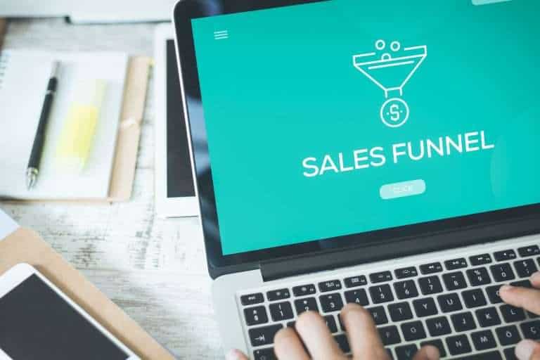 woman typing at laptop the words sales funnel on the screen